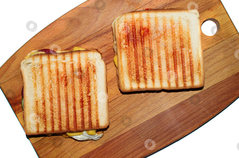 Скачать Бутерброды на деревянной доске, выделенные на белом фоне. Тосты с сыром и яйцами, свежий завтрак. Плоская поверхность фотосток Ozero