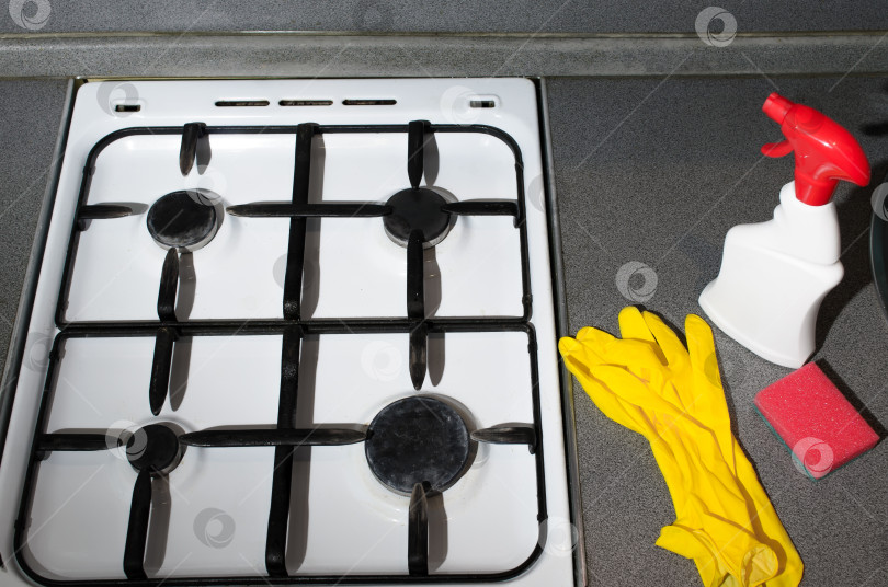 Скачать Грязная поверхность газовой плиты, желтые перчатки, губка для мытья посуды и чистящее средство. Концепция бытовой гигиены. фотосток Ozero