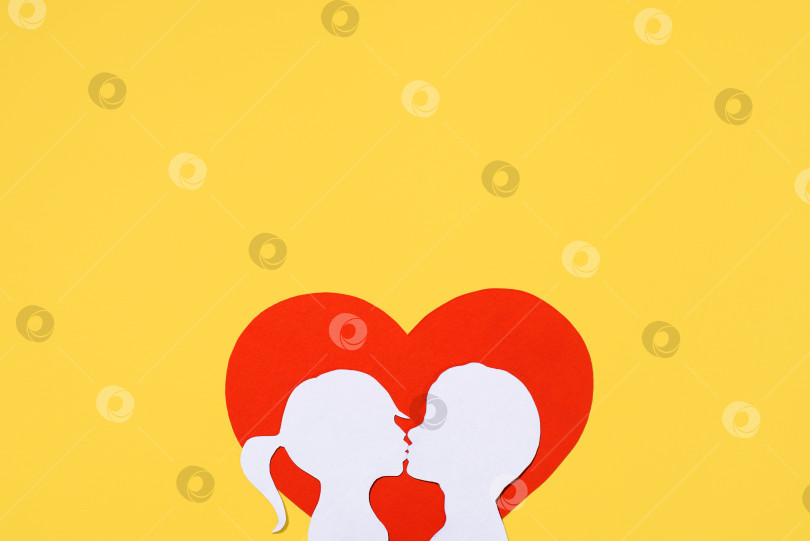 Скачать Силуэты целующихся девочки и мальчика на фоне в форме сердца. Концепция Дня святого Валентина. Креативная любовная открытка. Плоское расположение, вид сверху, место для копирования фотосток Ozero