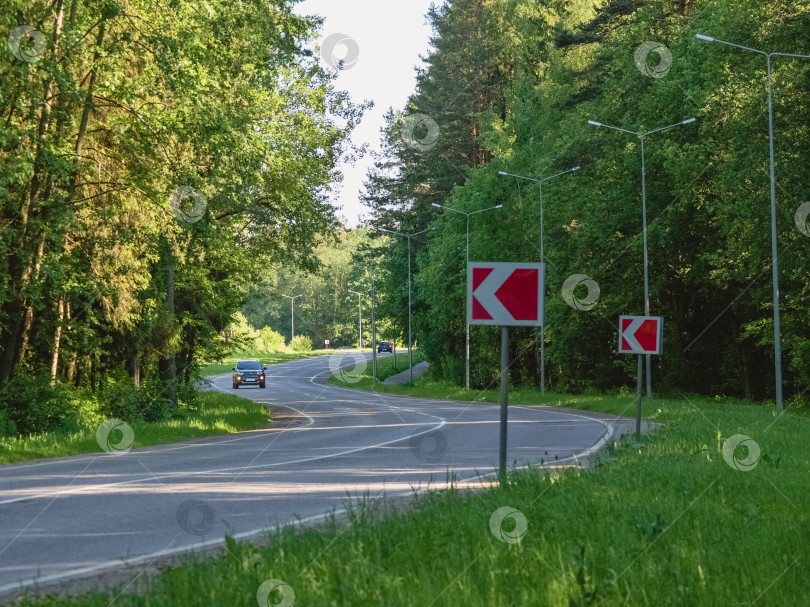 Скачать Автомобиль едет по извилистому шоссе в летнем лесу фотосток Ozero