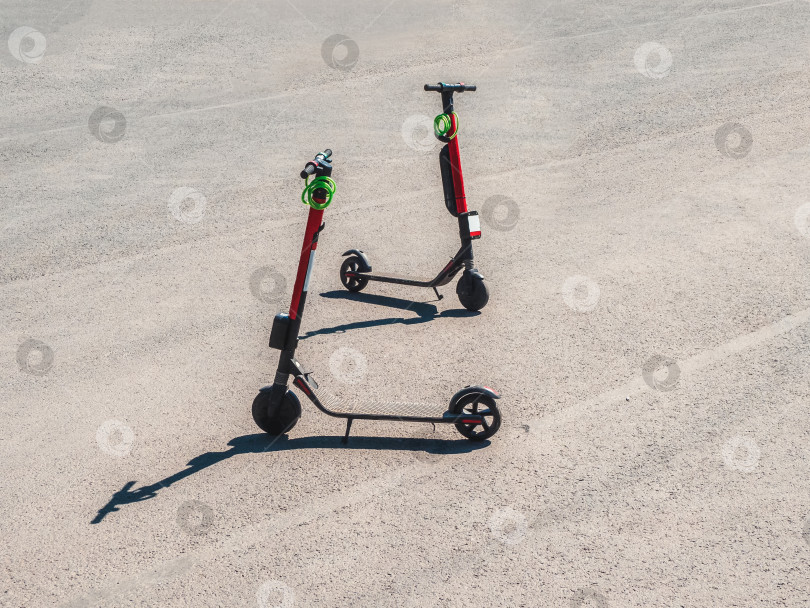 Скачать Два припаркованных скутера в летнем городе. Современный молодежный вид транспорта фотосток Ozero