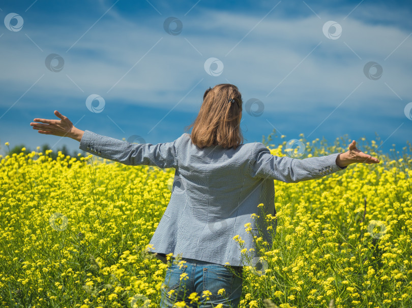 Скачать Счастливая девушка наслаждается красотой солнечного летнего дня в поле желтых цветов фотосток Ozero