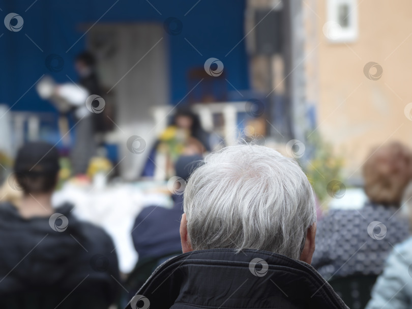 Скачать Активный пенсионер слушает оперу. Вид сзади на мужчину с седой головой на открытом воздухе фотосток Ozero