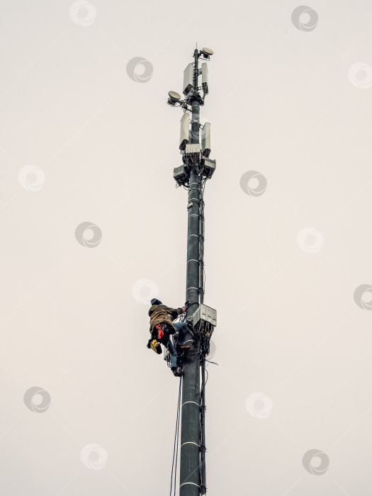 Скачать Высотный рабочий работает на вышке сотовой связи фотосток Ozero