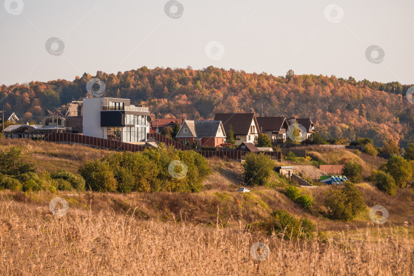 Скачать Загородная элитная недвижимость, современные коттеджи на осеннем холме. фотосток Ozero