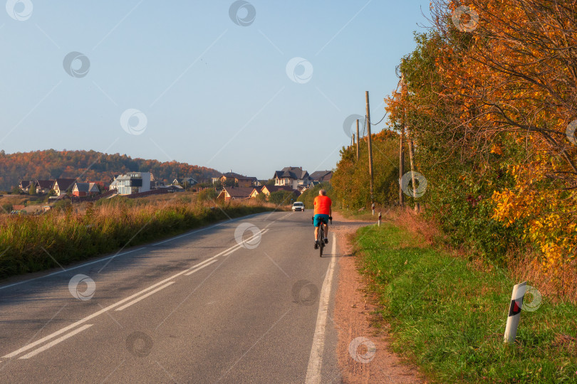 Скачать Путешествуйте на велосипеде. Мужчина-велосипедист на загородной осенней дороге. фотосток Ozero
