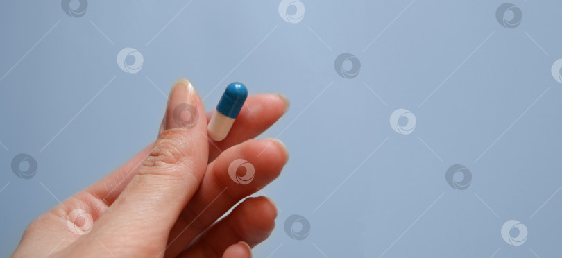 Скачать таблетка в руке на синем фоне, лекарство, день медицинского работника, медицинская помощь, баннер для больницы фотосток Ozero