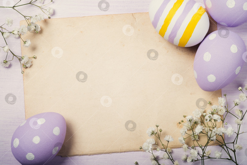 Скачать Красочные пасхальные яйца и цветы на старом листе бумаги с местом для текста. Вид сверху фотосток Ozero