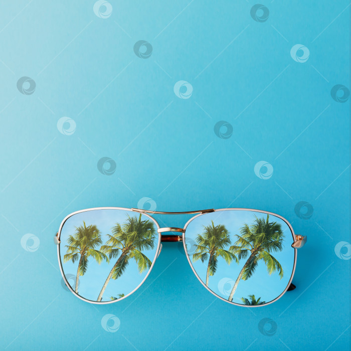 Скачать Солнцезащитные очки с отраженными в них пальмами и пространством для текста, концепция на тему туризма и путешествий фотосток Ozero