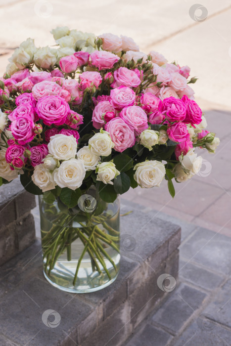 Скачать Цветы в стеклянной вазе на ступеньках цветочного магазина. Свежие пионовидные розы снаружи. Цветы на улице фотосток Ozero