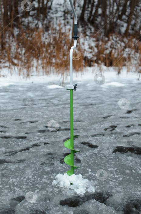 Скачать Сверло, стоящее во льду. Снаряжение для зимней рыбалки. фотосток Ozero