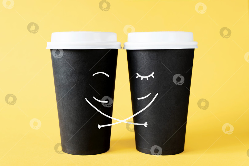 Скачать Влюбленная пара кофейных чашек. Обнимающие одноразовые кофейные чашки на желтом фоне. Творческая концепция романтических отношений фотосток Ozero