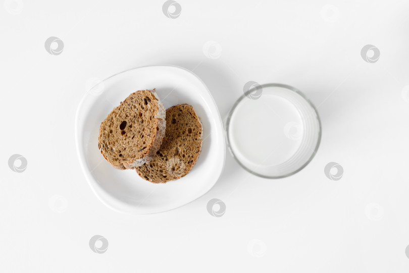 Скачать Завтрак с молоком и хлебом из хлопьев на белом столе, вид сверху. Концепция здорового завтрака "Доброе утро". Минималистичная фотография фотосток Ozero