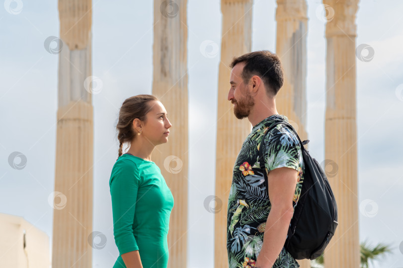 Скачать мужчина и женщина-туристы смотрят друг на друга на фоне древних колонн фотосток Ozero