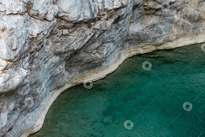 Скачать камни и вода, берег горного озера с голубой водой среди скал фотосток Ozero