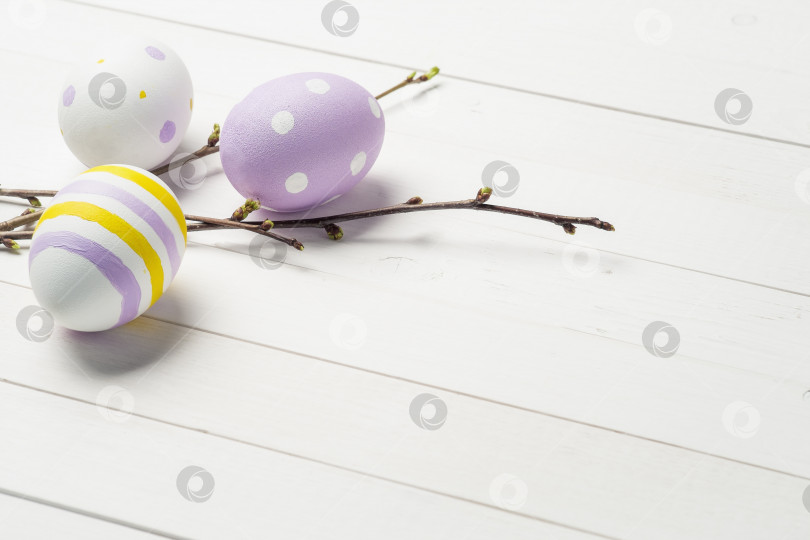 Скачать Красочные пасхальные яйца с веточками вишни на фоне окрашенного дерева и местом для текста фотосток Ozero