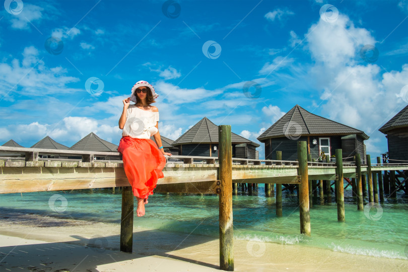 Скачать Девушка на деревянном мосту возле водных бунгало (Мальдивы - атолл Лавияни) фотосток Ozero