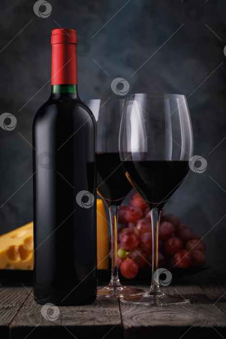 Скачать Два бокала красного вина с сыром и виноградом на деревянном столе. Натюрморт с алкоголем фотосток Ozero