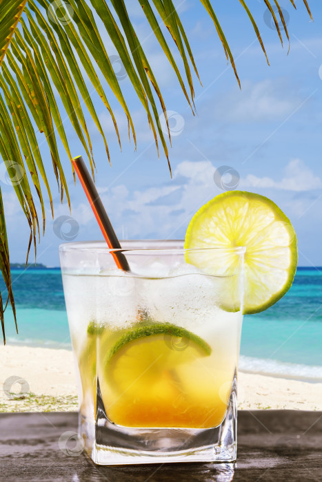 Скачать Классический бразильский коктейль из кайпириньи. Свежеприготовленный алкогольный напиток на фоне океана с пробелом для текста фотосток Ozero