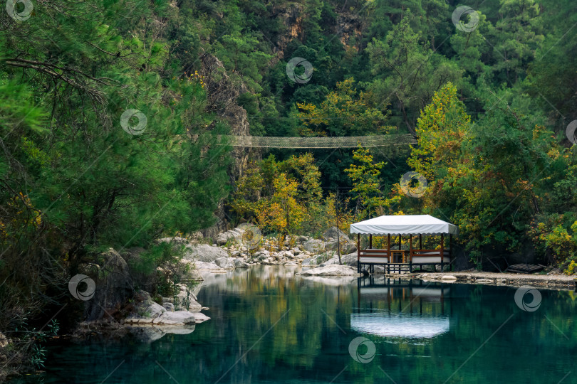 Скачать осенний горный пейзаж с тенистым озером, беседкой для пикника и висячим мостом фотосток Ozero