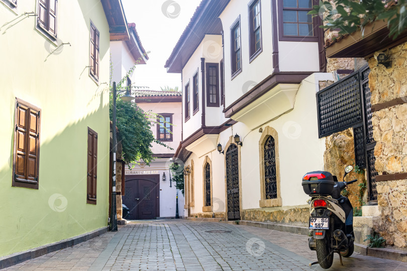 Скачать мотоцикл, припаркованный на узкой улочке в Калеичи - историческом районе Анталии, Турция фотосток Ozero