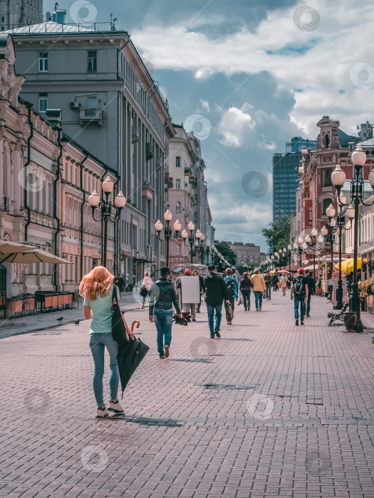 Скачать Улица Арбат с гуляющими туристами в солнечный летний день после дождя. Москва фотосток Ozero