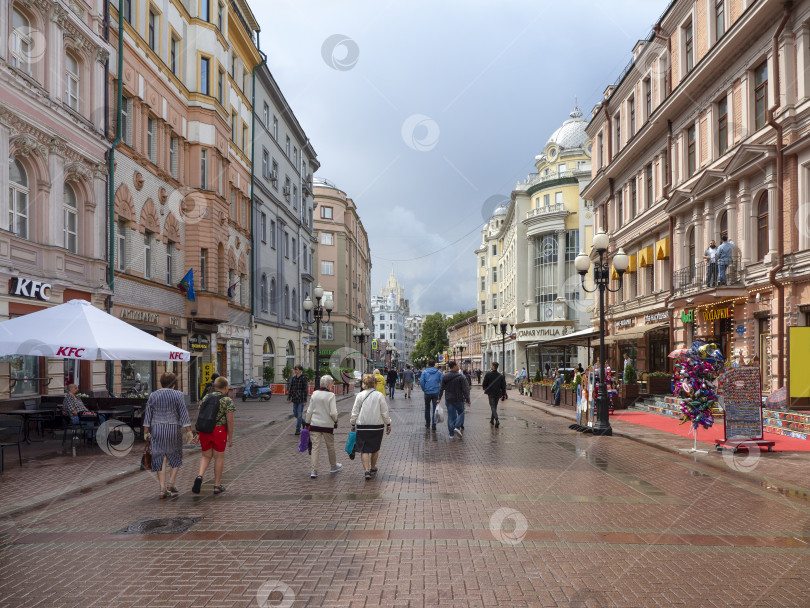 Скачать Москва - 31 июля 2020 года: улица Арбат с гуляющими туристами в солнечный летний день после дождя фотосток Ozero