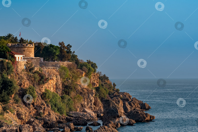 Скачать скалистое побережье исторической части Анталии с древней башней Хидирлик фотосток Ozero