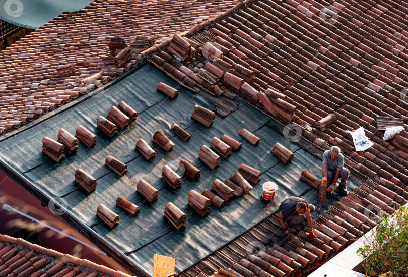 Скачать Кровельщики ремонтируют черепичную крышу исторического здания в Калеичи, Анталия фотосток Ozero
