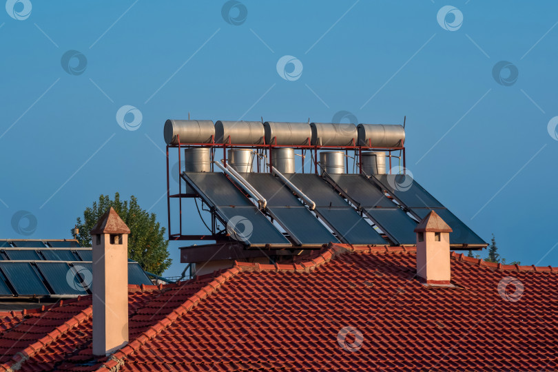 Скачать солнечные тепловые коллекторы, установленные на черепичной крыше дома фотосток Ozero