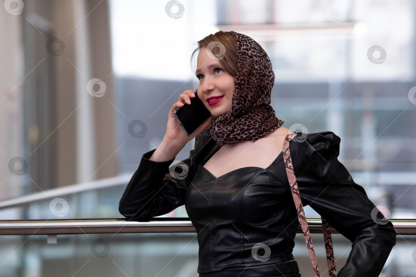 Скачать молодая красивая женщина в платке разговаривает по телефону фотосток Ozero