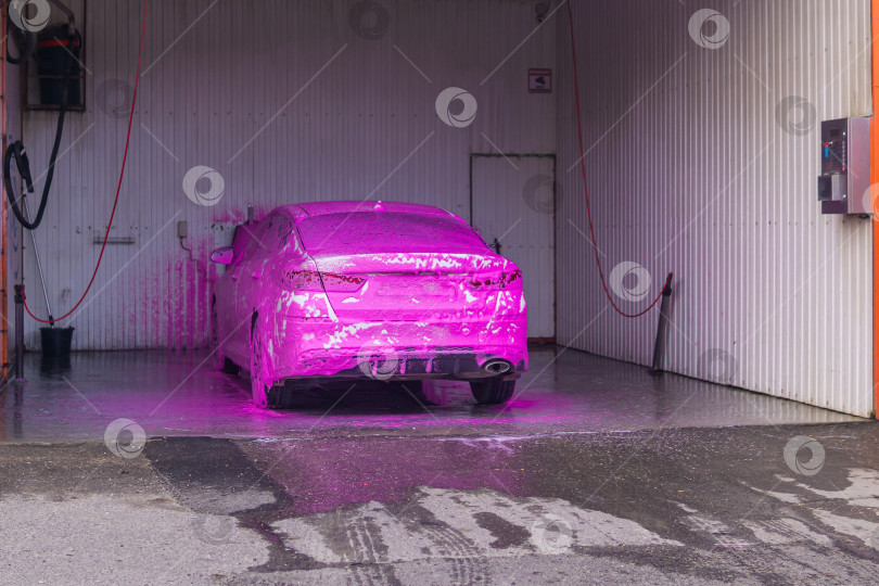 Скачать автомобиль на автомойке самообслуживания, покрытый розовым автомобильным шампунем фотосток Ozero