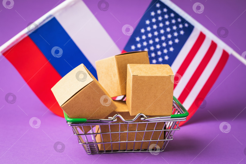 Скачать Различные коробки в продуктовой корзине и флаги России и Америки на цветном фоне, концепция торговли между странами Америки и Россией фотосток Ozero