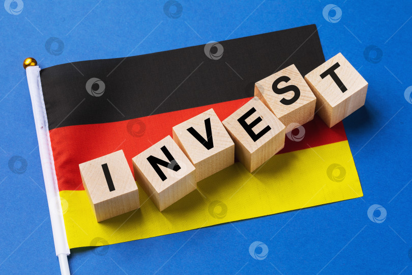 Скачать Деревянные кубики с текстом и флагом на цветном фоне, концепция инвестиций из Германии фотосток Ozero