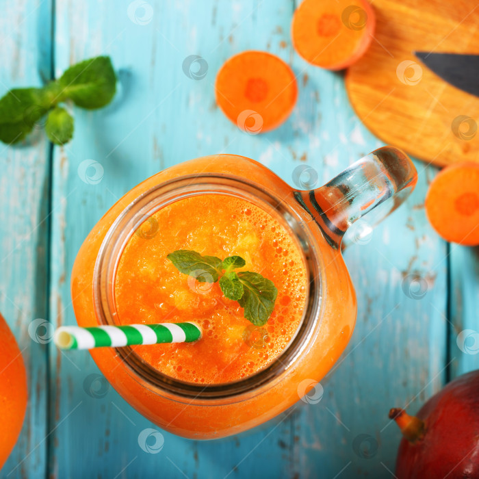 Скачать Смузи из манго, апельсина и моркови в стеклянной банке. Вид сверху на свежеприготовленный напиток фотосток Ozero