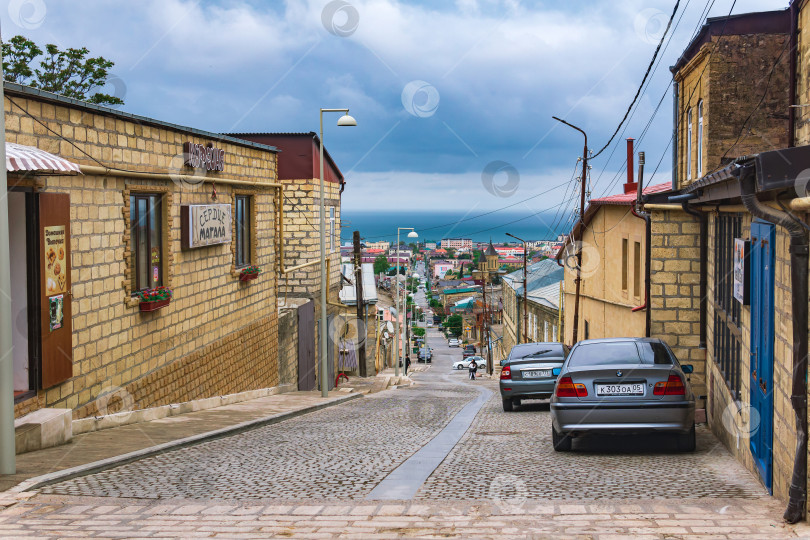 Скачать улица в историческом центре Дербента на склоне горы с видом на Каспийское море фотосток Ozero