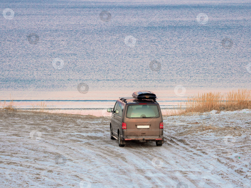 Скачать Автомобиль с багажником на крыше припаркован на берегу Северного Ледовитого океана. Концепция путешествия на автомобиле. Потрясающий вид на Северную бухту фотосток Ozero