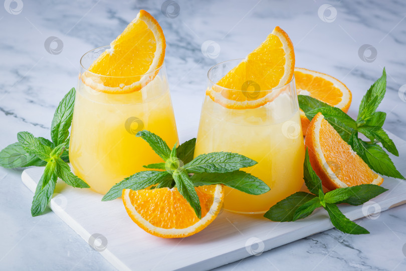 Скачать Стакан апельсинового сока со льдом. Холодный апельсиновый фреш. Стакан апельсинового сока в жаркий летний день фотосток Ozero