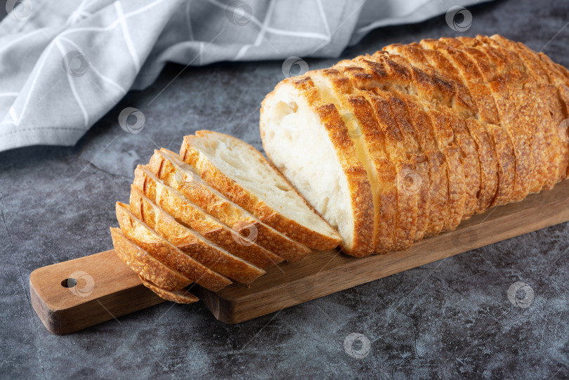Скачать Свежая белая буханка хлеба на сером цементном фоне. Вид сверху фотосток Ozero