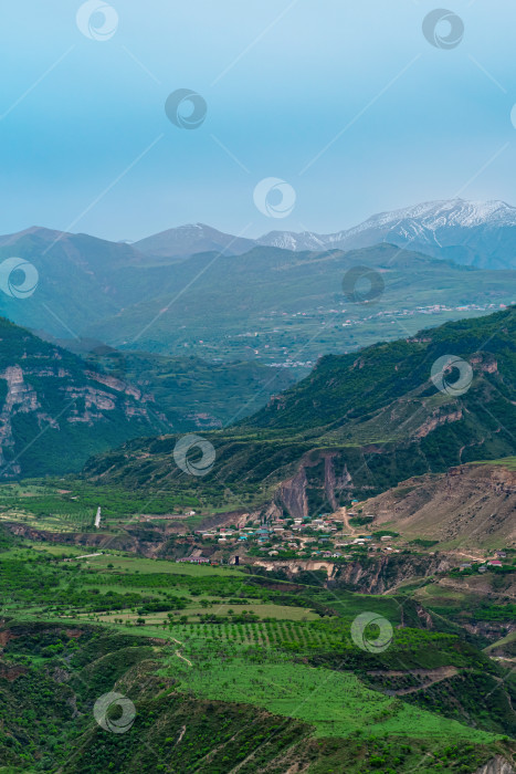 Скачать туманная альпийская долина с деревнями и полями между горными вершинами в Дагестане фотосток Ozero