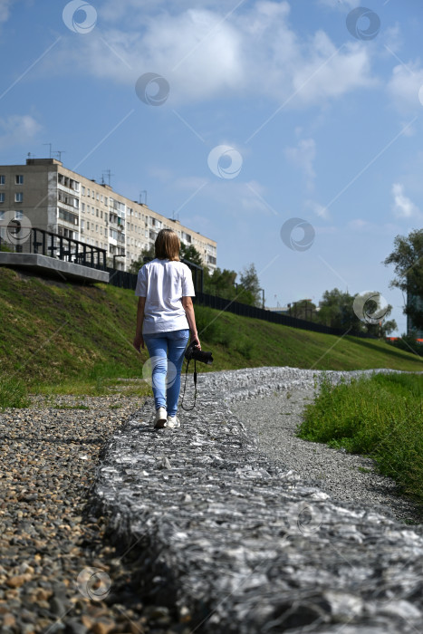 Скачать женщина-фотограф с фотоаппаратом в руках идет по улицам города фотосток Ozero