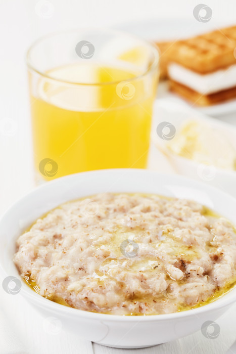 Скачать Полезный завтрак, каша с овсяными, пшеничными, ячменными и ржаными хлопьями и апельсиновым соком фотосток Ozero