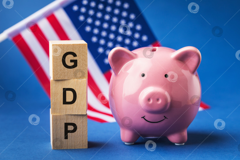 Скачать Копилка, деревянные кубики с текстом и флагом на синем фоне, концепт на тему ВВП Соединенных Штатов Америки фотосток Ozero