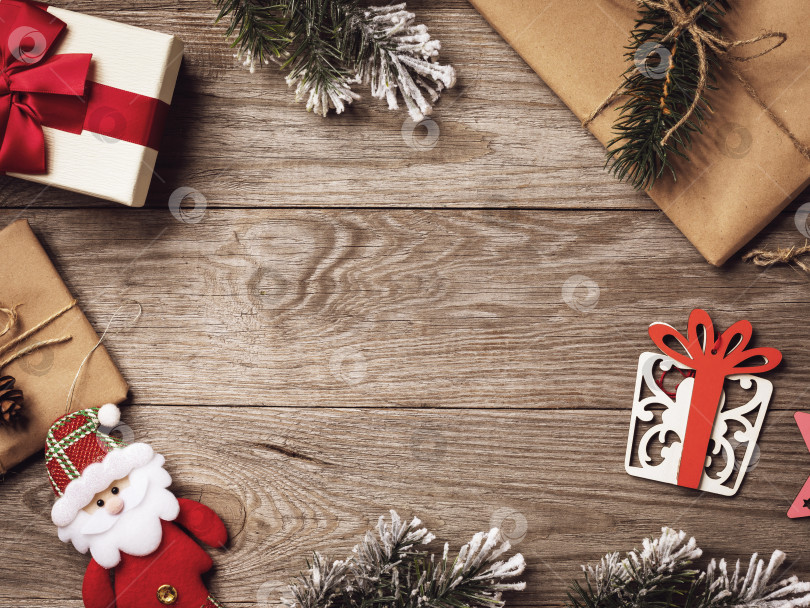 Скачать Различные рождественские украшения и подарки на деревянном фоне с местом для копирования в центре, вид сверху фотосток Ozero