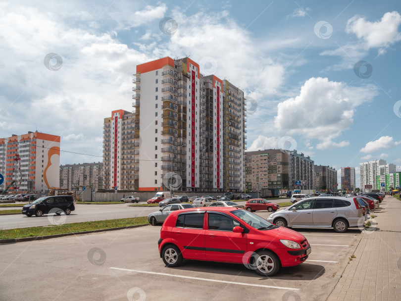 Скачать Красная машина на стоянке большого современного города. фотосток Ozero