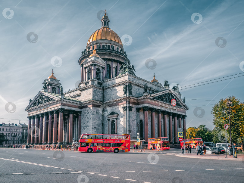 Скачать Туристический сезон в Санкт-Петербурге. Красные экскурсионные двухэтажные автобусы припаркованы у Исаакиевского собора. фотосток Ozero