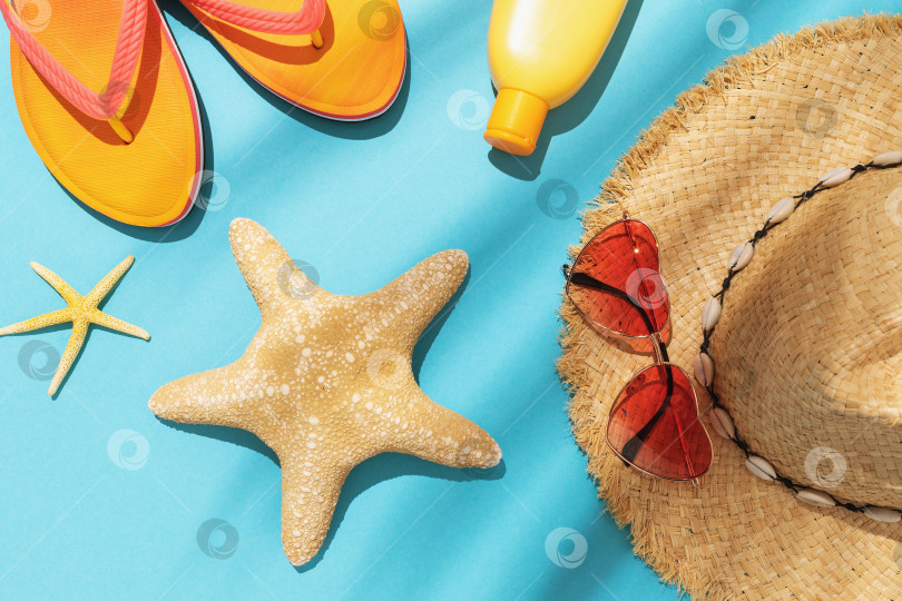 Скачать Морская звезда, пляжные тапочки, крем для загара, солнцезащитные очки и шляпа на синем фоне фотосток Ozero