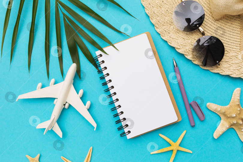 Скачать Чистый блокнот, ручка, игрушечный самолет и солнцезащитные очки на синем фоне фотосток Ozero