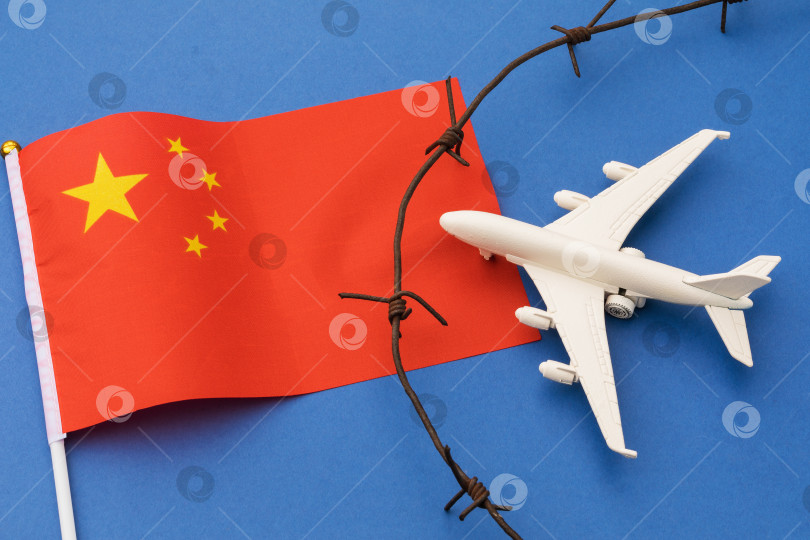 Скачать Флаг Китая, колючая проволока и игрушечный самолет на синем фоне, концепция нарушения воздушной границы фотосток Ozero