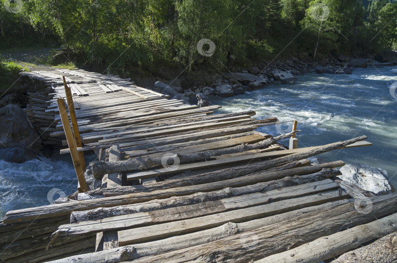 Скачать Старый полуразрушенный мост через горную реку. фотосток Ozero